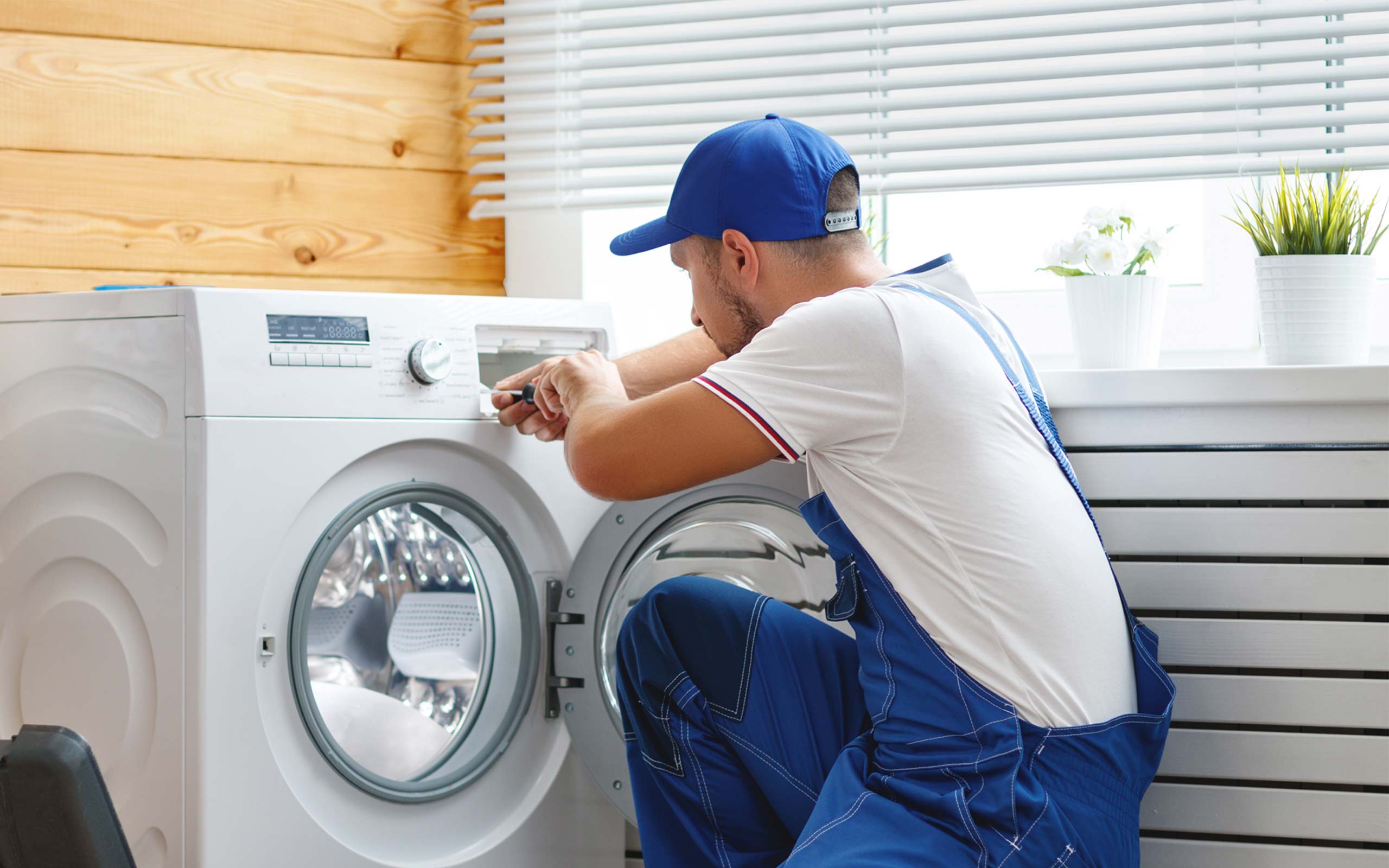 Technician repairing a front-loading washing machine